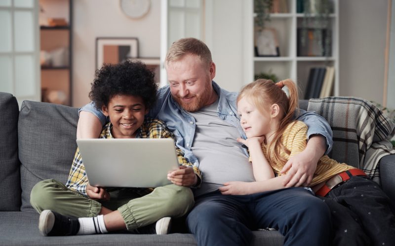 Father with children using laptop at home