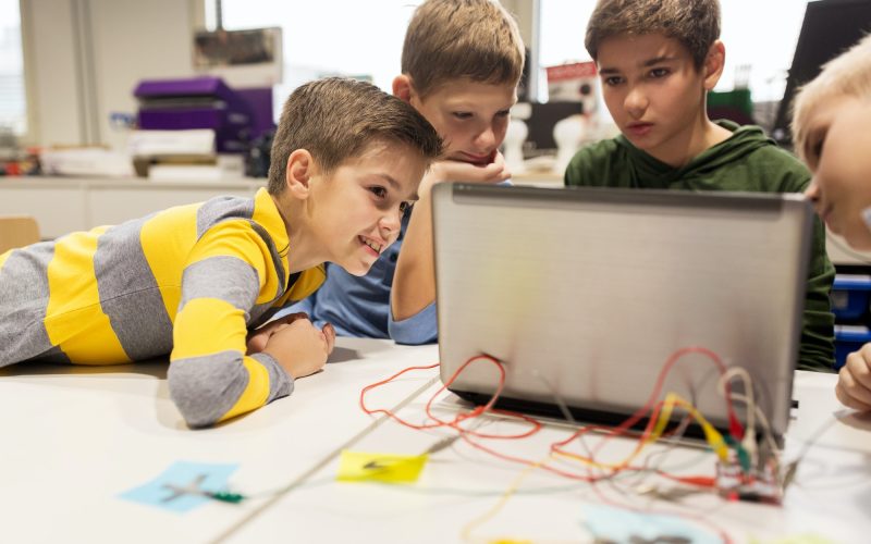 kids, laptop and invention kit at robotics school